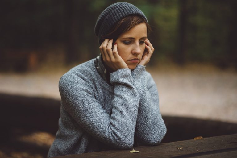 girl depressed on table at park