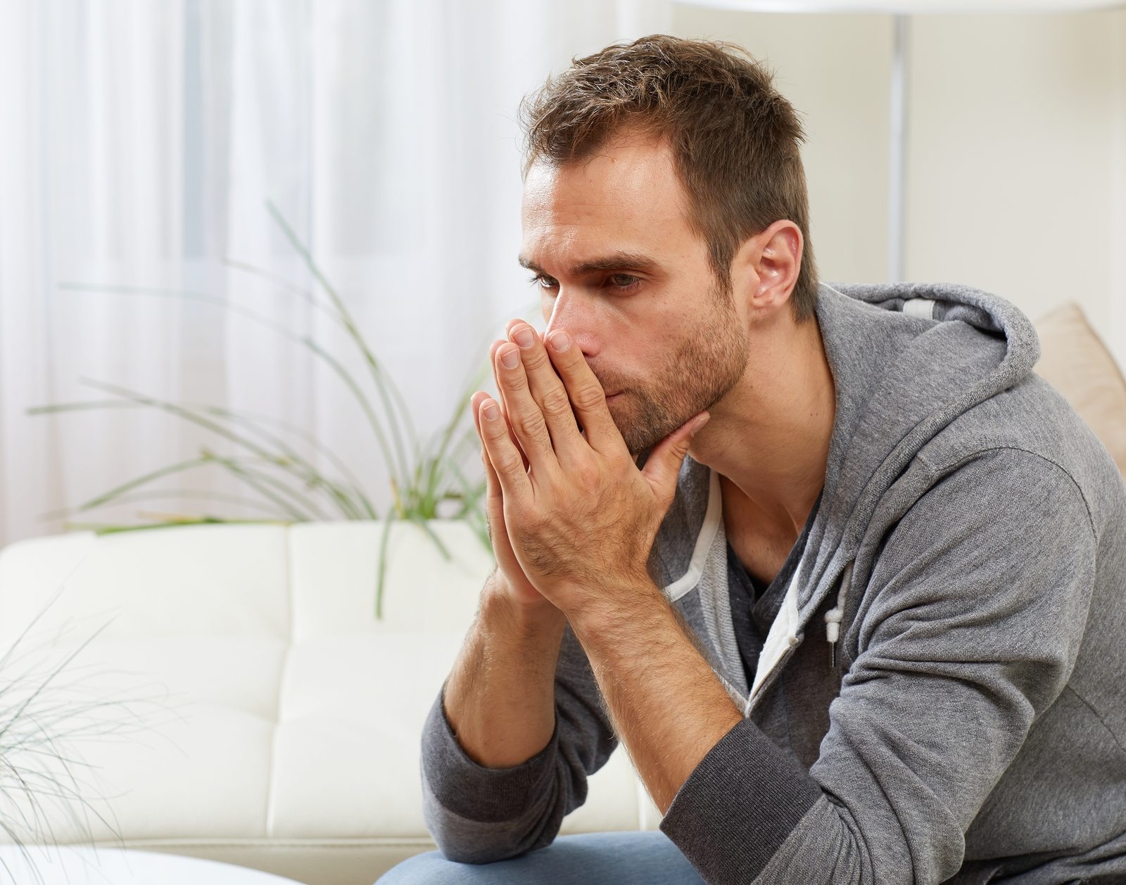 Anxious man with hands in front of face