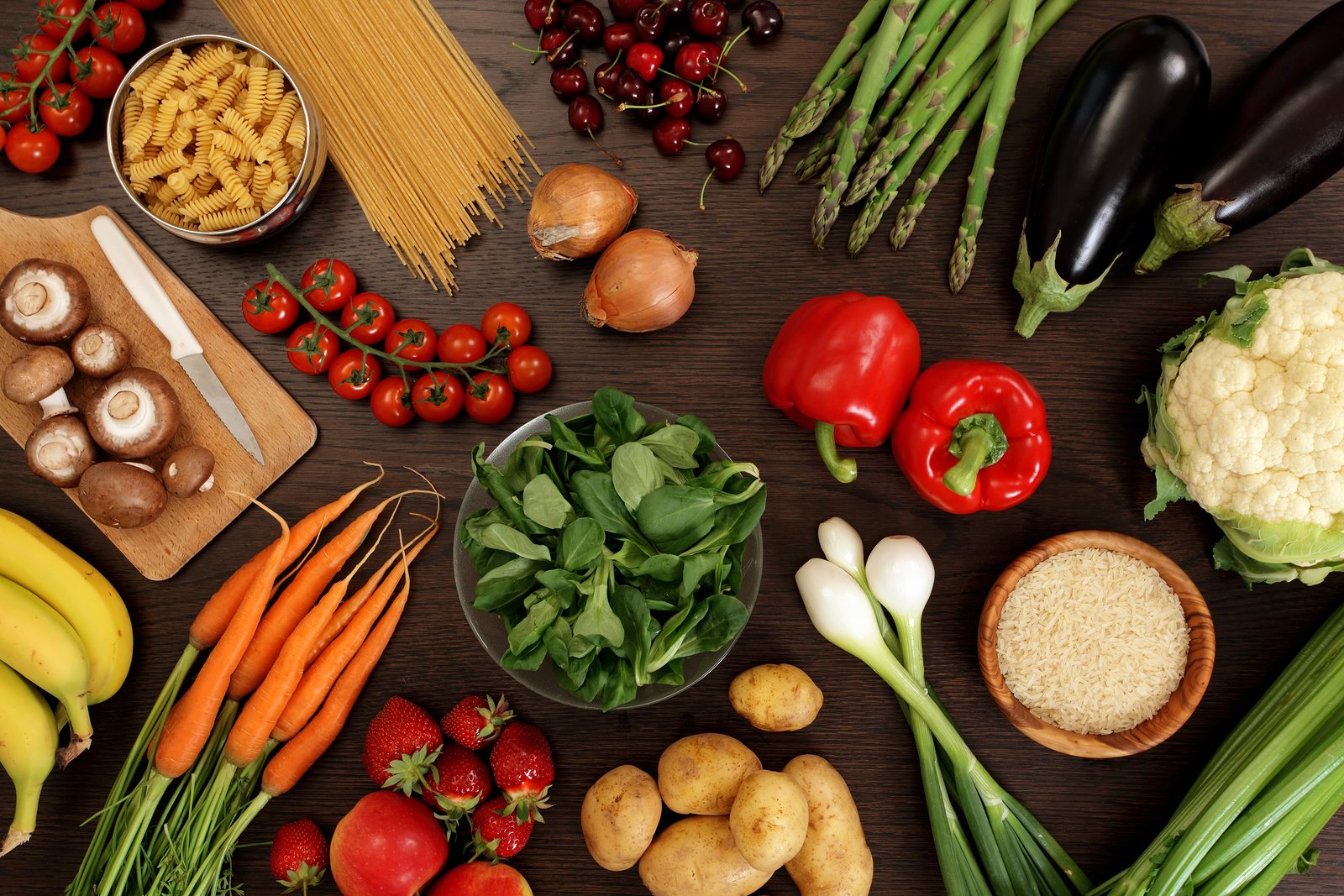 Photo of a table top full of fresh vegetables fruit and other healthy foods.