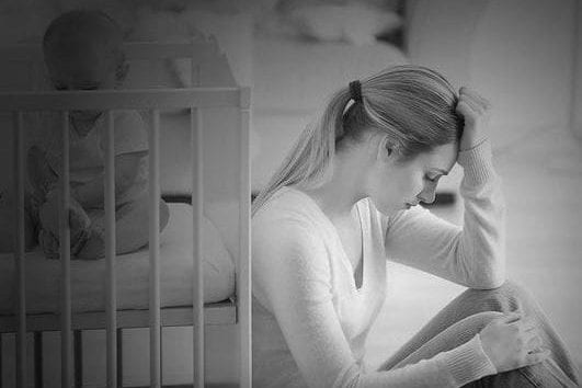 depressed mother with child in crib