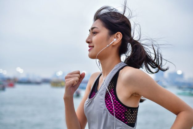 Young woman running with headphones in