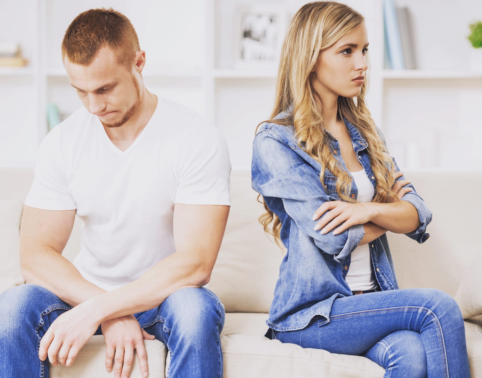 Young Couple Having Big Trouble in Relations. Angry Woman Sitting Back to Her Husband. Family Couple Arguing on Couch at Home. Unpleasant Situation in Handsome Guy with Beautiful Girl.