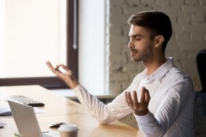 Man meditating at his desk