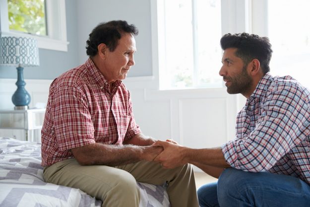 adult son comforting father suffering from alzheimer's