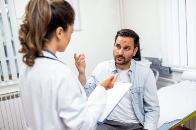 Young female professional doctor physician consulting patient, talking to adult man client at medical checkup visit. diseases treatment. medical health care concept