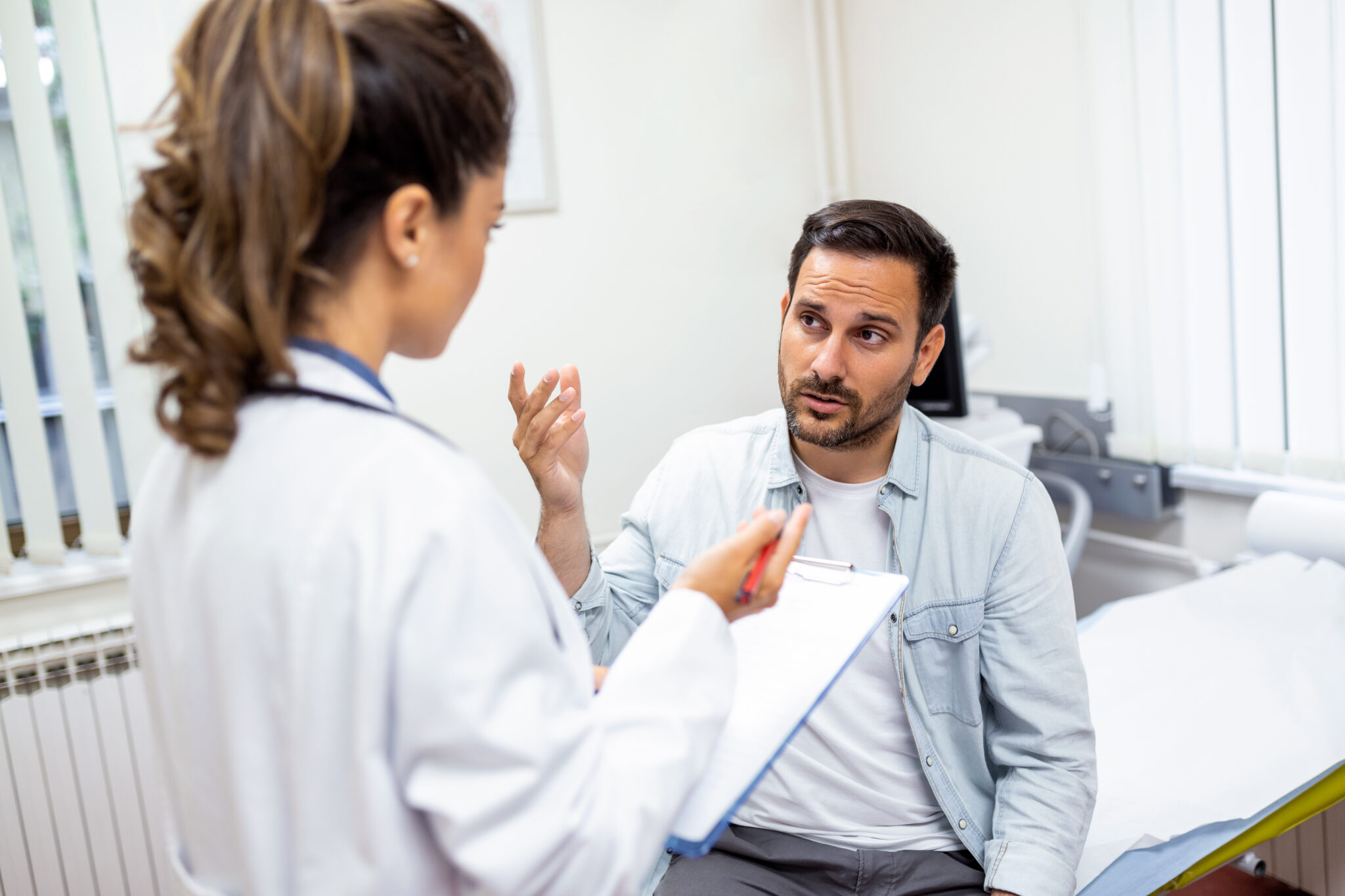 Young female professional doctor physician consulting patient, talking to adult man client at medical checkup visit. diseases treatment. medical health care concept